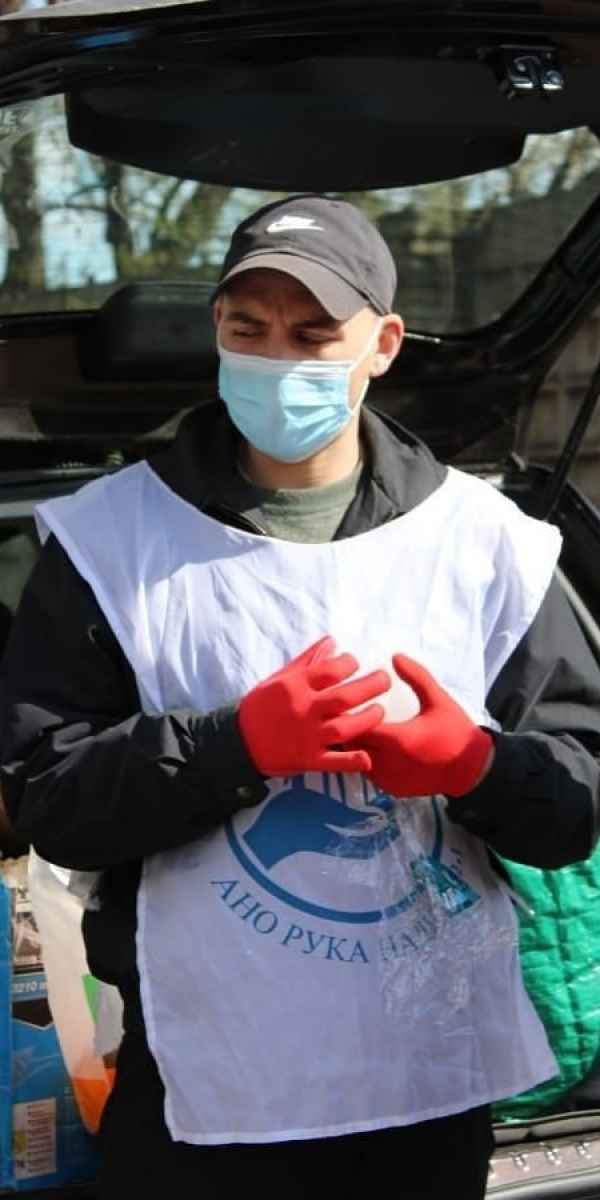 волонтер фонда кормит бесплатными обедами бездомных людей